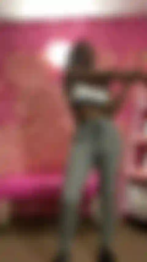 Me alongando em moletom cinza e sutiã esportivo.