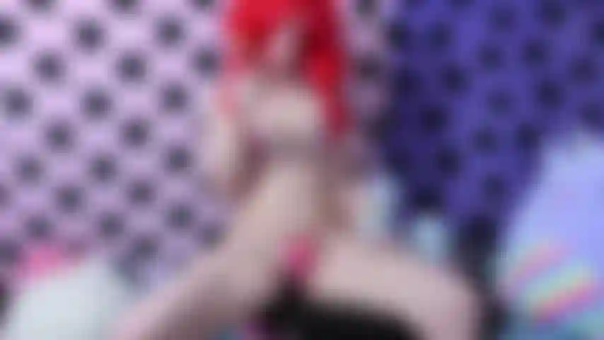 Masturbação fofa com vibrador de chifre de unicórnio em tons pastéis em biquíni de coração e peruca vermelha enquanto lambe um pirulito colorido.