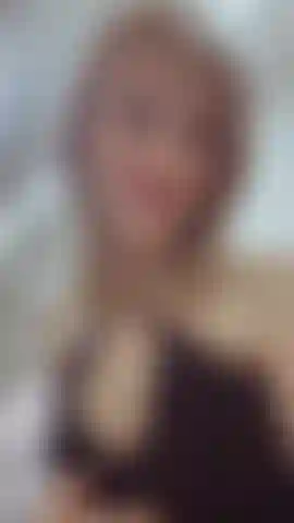 O tecido fino cai suavemente sobre o corpo, delineando a silhueta. Há um desafio em seus olhos, e a graça de um predador em seus movimentos.