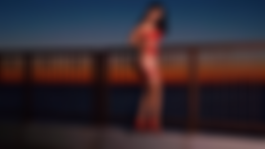 Provocadora sensual em topless na praia do nascer do sol.