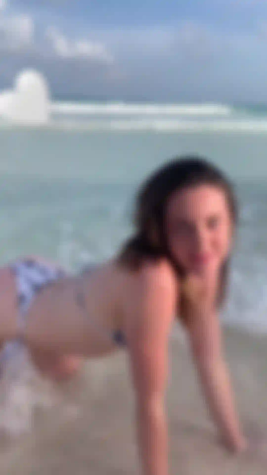 Spiritual beach babe splashing in waves