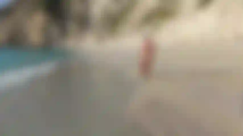 Teasing, stretching and posing in doggy style at a nude beach, whilst some people were watching.