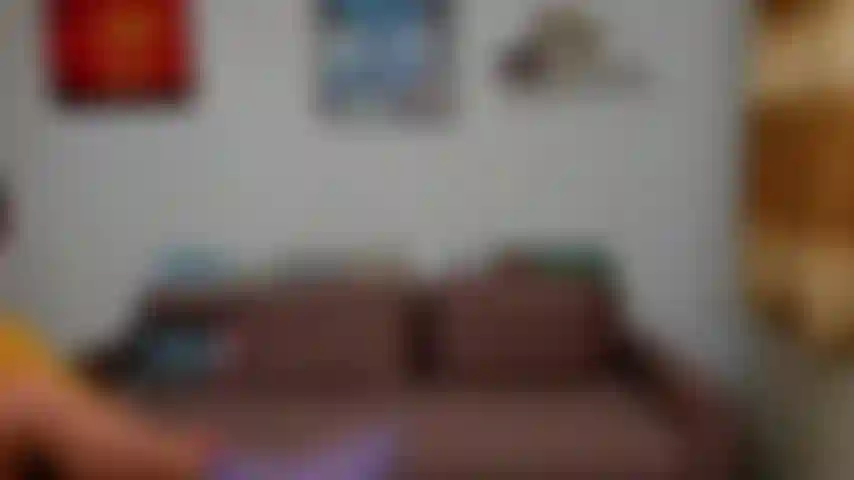 Exibindo minha bunda e bolas de joelhos no sofá.