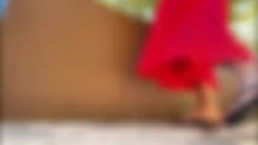 Vestido vermelho, sola de saia, chinelos, dedos vermelhos e rosa.