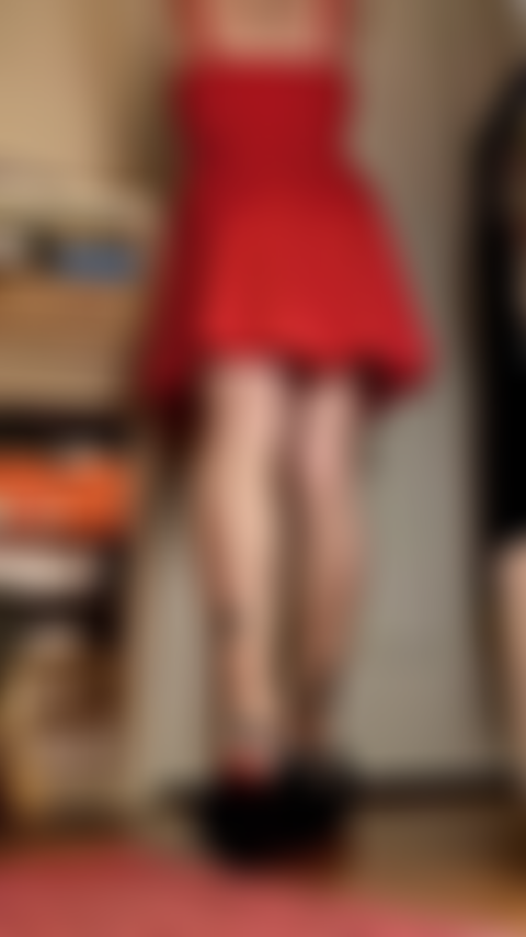 Vestido vermelho, pernas longas curvadas, solas à mostra.