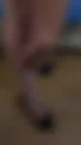 A cute skinny girl gently strokes herself with her hand in a black skirt