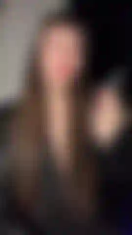 A deusa emily fumando em couro e renda com lábios vermelhos.