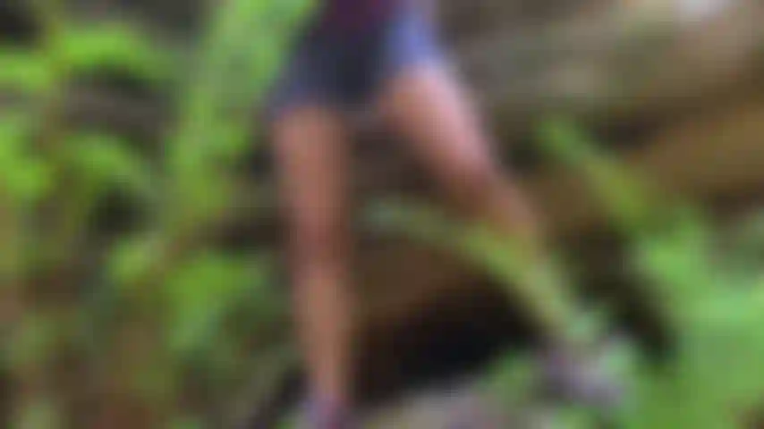 Cumming na floresta por um riacho.