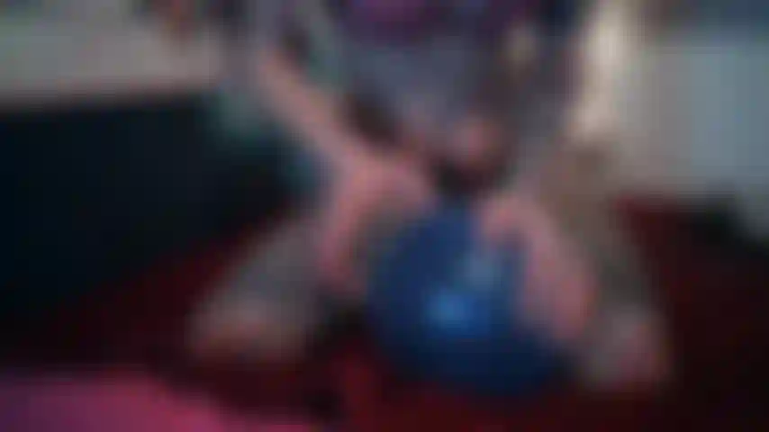 Estourando um balão entre as pernas sem calcinha.