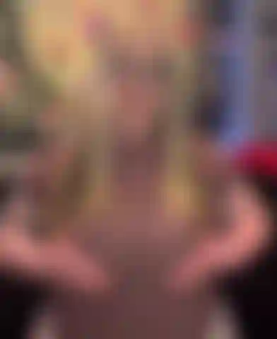 Com seios à mostra em uma blusa justa.