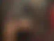 Uma senhora vestida com botas de borracha pretas, altas e brilhantes, combinadas com uma roupa sexy de látex preto brilhante.