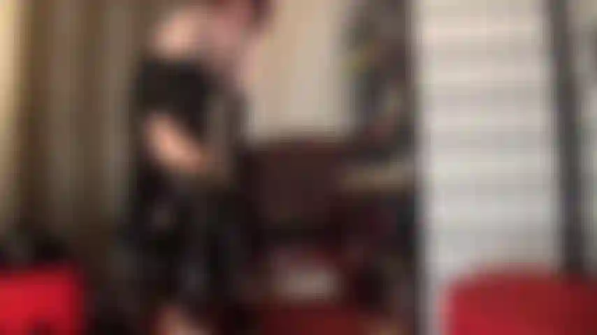 Admiro minhas curvas brilhantes no macacão preto de pvc.