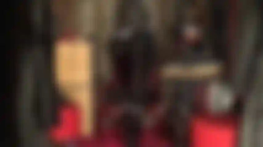 A mulher-gato exige adoração de suas curvas brilhantes em um macacão de pvc, exibindo sua bunda e pernas perfeitas em botas.