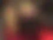 Shorts de cetim dourado brilhante, meia-calça brilhante e botas de cano alto.