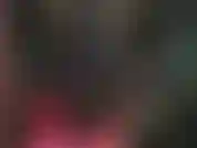 Amante de látex, com uma roupa preta justa de borracha e botas de salto agulha sensuais.