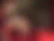 Vista lateral de pernas sensuais em meias costuradas e ligas com saltos pendurados.