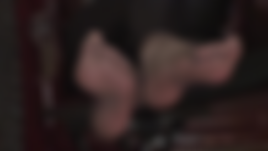 Tornozelos cruzados, solas macias e dedos sensuais em meias de náilon sedosas - os pés da amante, de meia-calça preta transparente, provocam o amante dos pés.