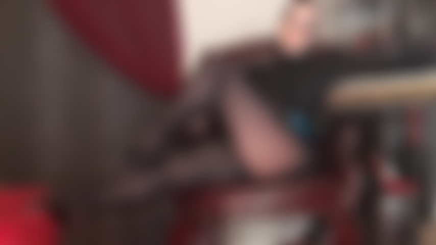 A mistress seduz com suas pernas em meia-calça preta brilhante e um decote sexy em sutiã de renda.