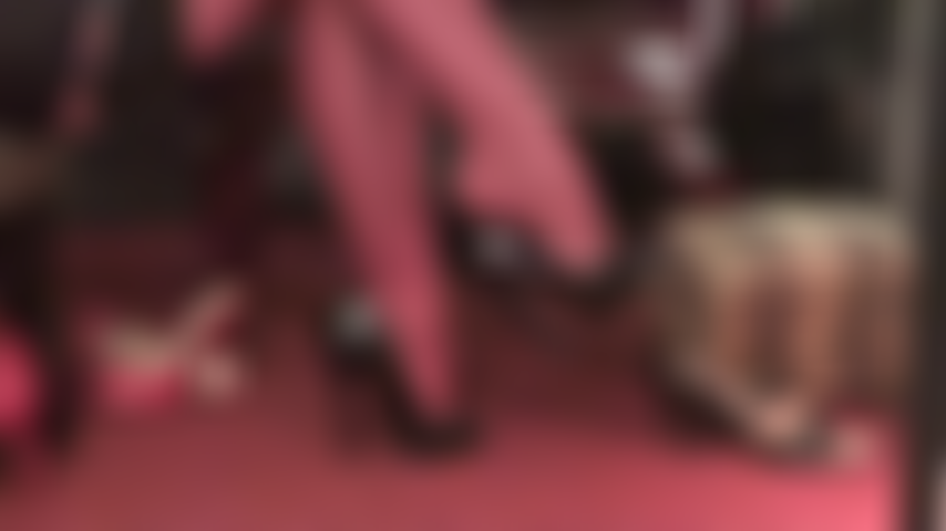 Observe a rainha balançando em meias-ligas vermelhas e peep toes pretos de verniz.