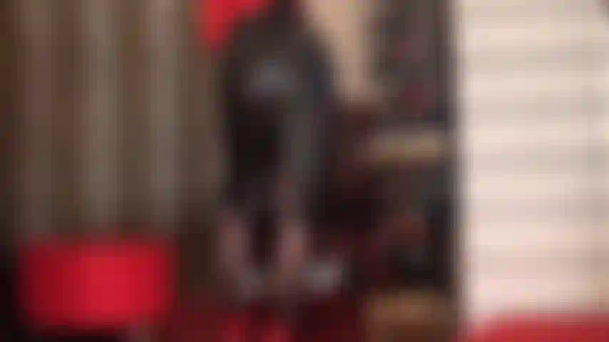 Com saia lápis de couro preta e meia-calça preta.