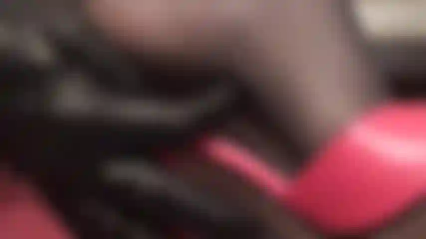 De perto e pessoalmente, com saltos de amante e pés em meias pretas e mules vermelhas.