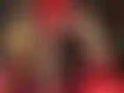 A senhora provoca com suas coxas bem torneadas e pernas longas e finas em meia-calça brilhante e shorts de cetim vermelho brilhante.