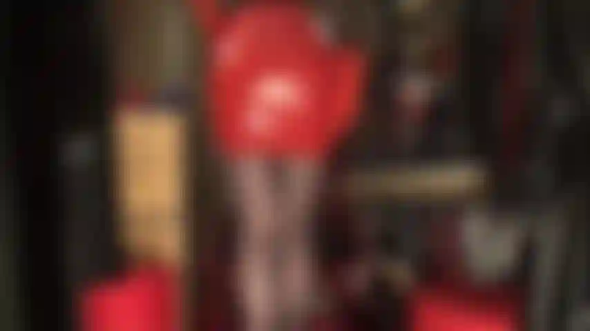 Saia sexy de látex vermelha, luvas de borracha, meia-calça preta e saltos vermelhos.