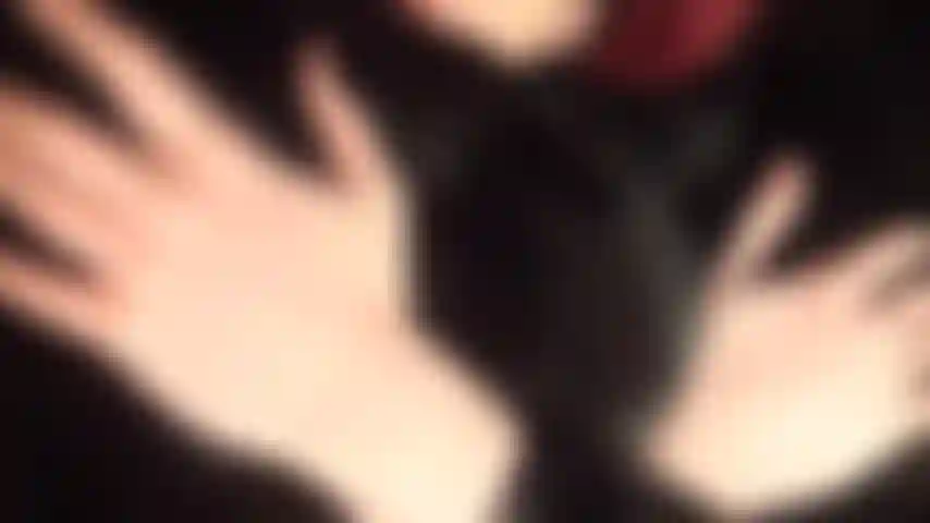 Vestindo um lindo casaco de pele preta e macia sobre um body de pvc e meia-calça arrastão vermelha.