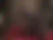 Calçando meias de látex pretas e vermelhas e luvas até os ombros, além de sapatos peep toe brilhantes.