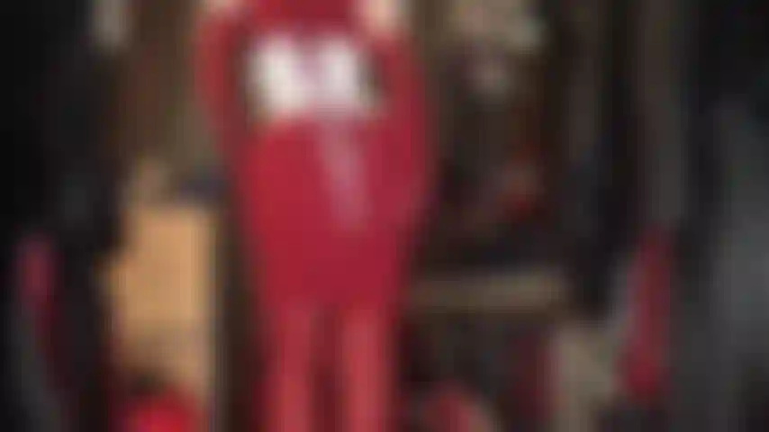 A dama de vermelho - adoração corporal das curvas maravilhosas da senhora em um vestido vermelho de malha justo, botas de couro acima do joelho e luvas combinando.