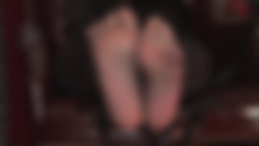 Pés sensuais balançando em meias-calças pretas transparentes provocando o escravo dos pés.