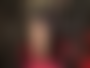 Uso meia-calça nude sexy, cabelo preto, couro preto, body vermelho e sapatos de salto alto com tiras vermelhas no tornozelo.