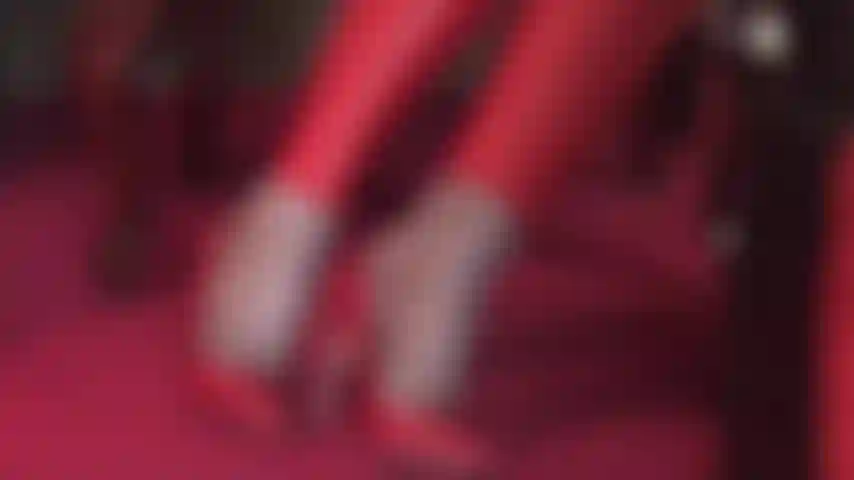 Com provocação nos pés, sapatos de couro vermelho e leggings combinando.