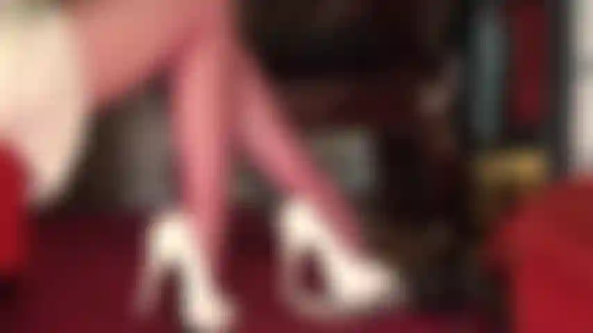 Com belas coxas e pernas em meia-calça vermelha com vista para cima em uma linda saia de cetim.