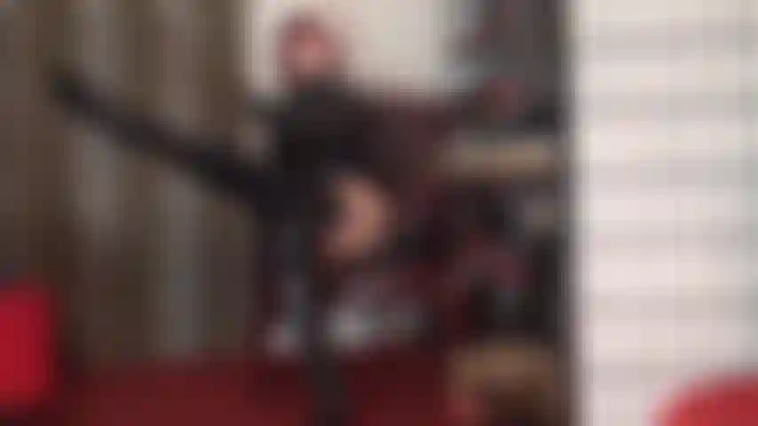 Com botas brilhantes acima dos joelhos, meias de pvc e ligas sobre meia-calça bege - as curvas brilhantes e sensuais da amante te deixam louco.