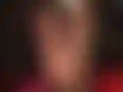 Com pernas e pés de meia-calça preta brilhante, vestindo camisa e gravata, casaco de couro e luvas. Gostosa!