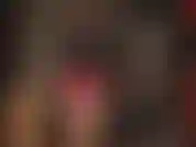 Com camadas de látex: meias transparentes, um minivestido vermelho, luvas pretas e uma camisa preta de botões. Gostosa!