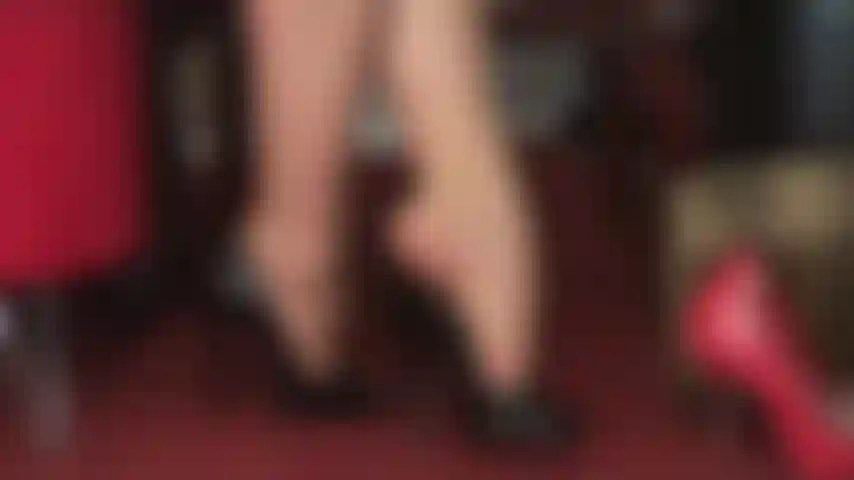 Fetiche por pés, adoração por saltos altos, balançando - lindos peep toes pretos e brilhantes balançam nos dedos das meias-calças da amante.