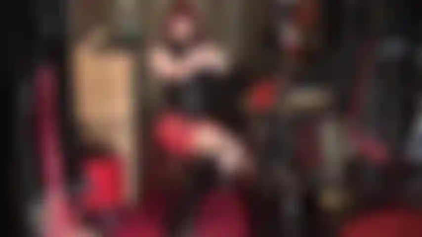 Tenho fetiche por látex - roupa de borracha vermelha e preta com botas de cano alto.