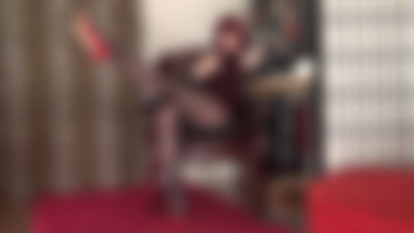 Com pernas longas e esticadas, brinco de sapatos e saltos altos vermelhos, fetiche por pés.