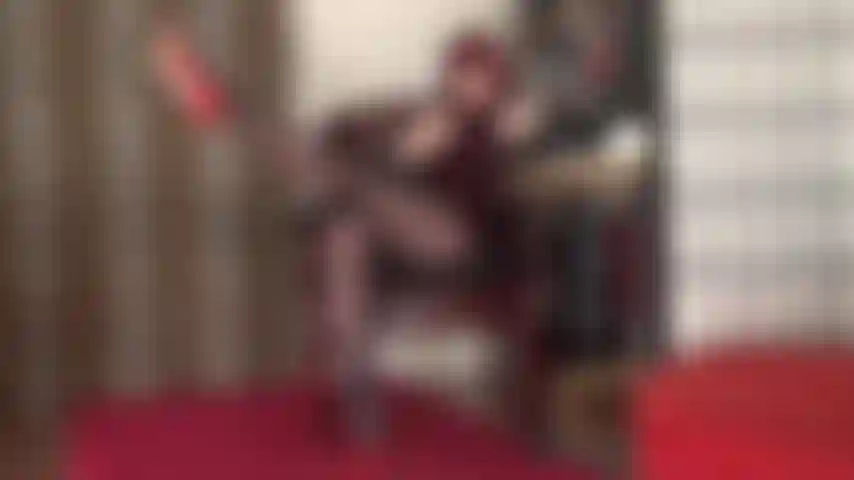 Com pernas longas e esticadas, brinco de sapatos e saltos altos vermelhos, fetiche por pés.