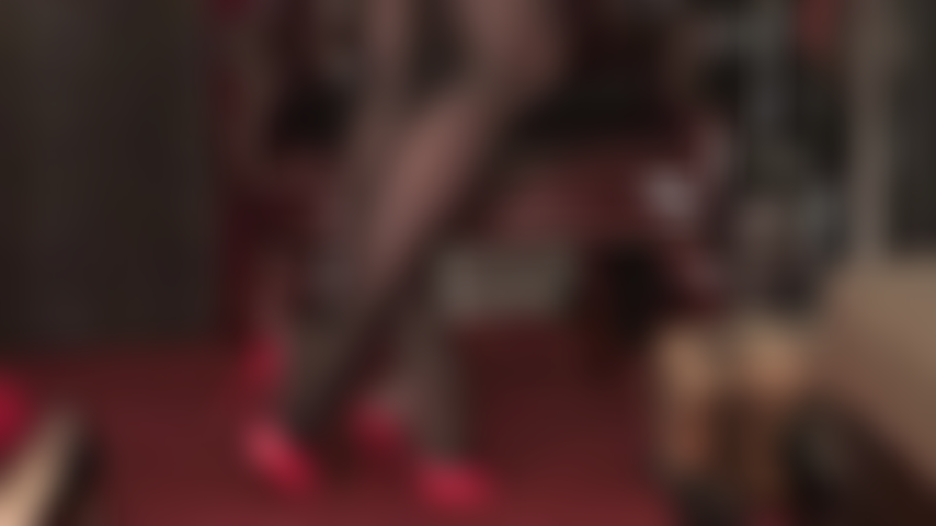 Uso meia-calça preta extra brilhante com brilho de óleo e mules vermelhos de salto alto.