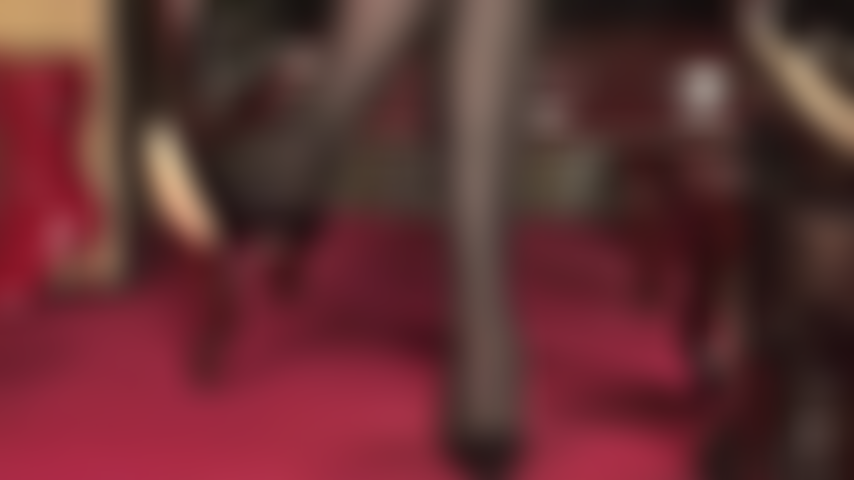 Que brinca de sapato e fica balançando com meia-calça preta e salto de aço e sapatos pretos de verniz.