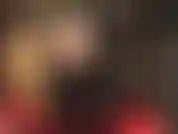 Uma visão sob a saia larga e sexy de vinil da amante revela meia-calça preta transparente e botas altas e brilhantes.