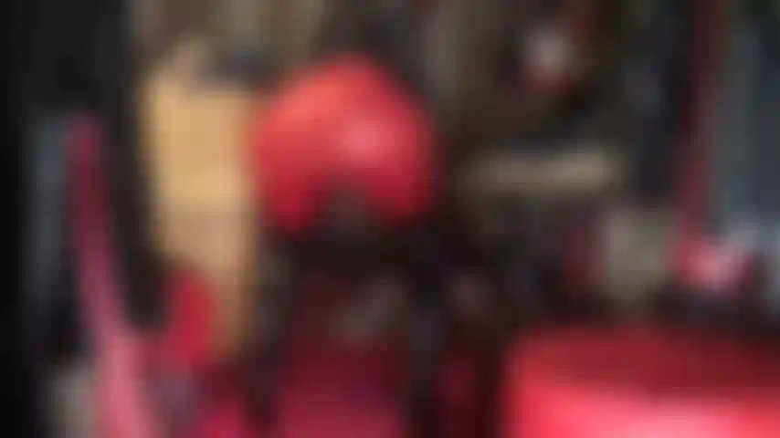 Que pratica facesitting e adoração de bundas, usando leggings vermelhas, botas de verniz brilhantes acima do joelho e capuz de spandex.