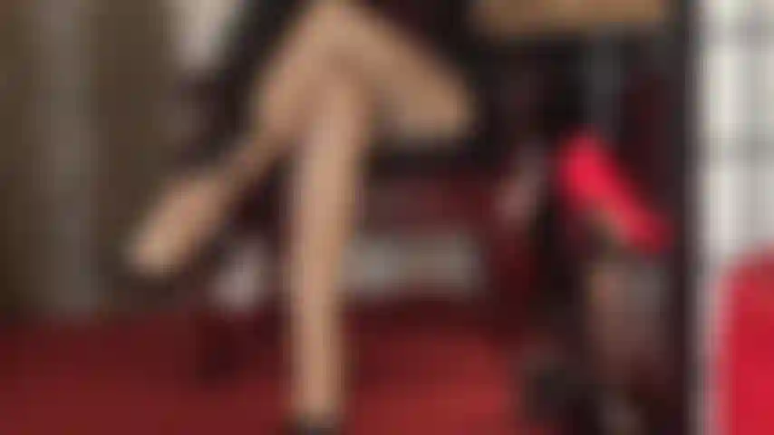 Pernas cruzadas sensuais em meia-calça bege brilhante provocando a amante das pernas. A senhora adiciona um par extra de meias brilhantes para um brilho irresistível.