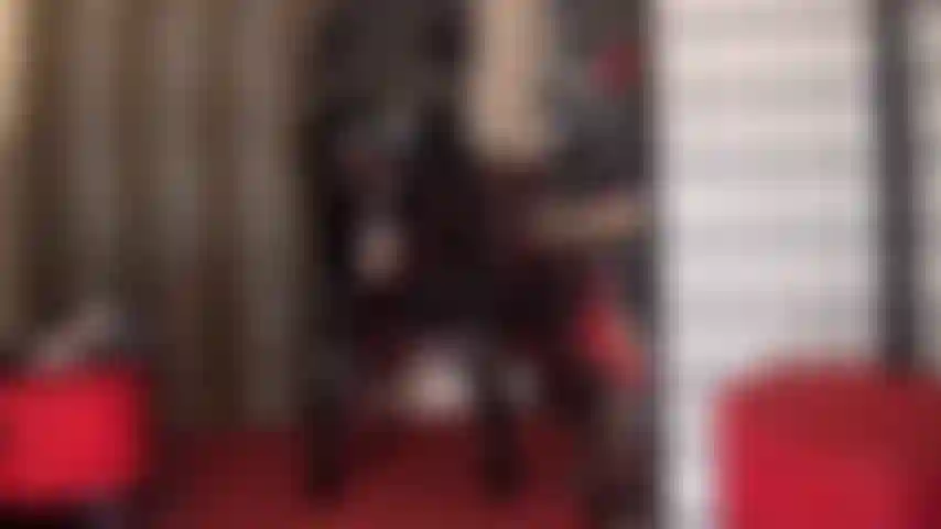 Uma deusa do pvc, vestida com um macacão preto brilhante, provocando com seu enorme pau branco saindo por baixo da saia.