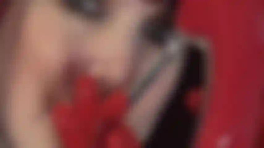 Com luvas fetichistas de látex vermelho, saltos de aço vermelho, sapatos de verniz e um pau preto provocante.