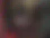 Uma amante de látex pervertida com capuz, luvas, botas e uma grande cinta-liga branca.