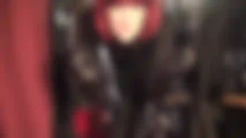 A senhora está vestida com uma saia de couro preta elegante, blusa de cetim, botas de amarrar e luvas de couro longas, provocando com maravilhosas pernas de meia-calça de seda por baixo.